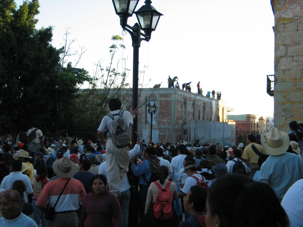 Demonstrators climb on roof top, awaiting the federal police (PFP) to come close enough for them to hit them.